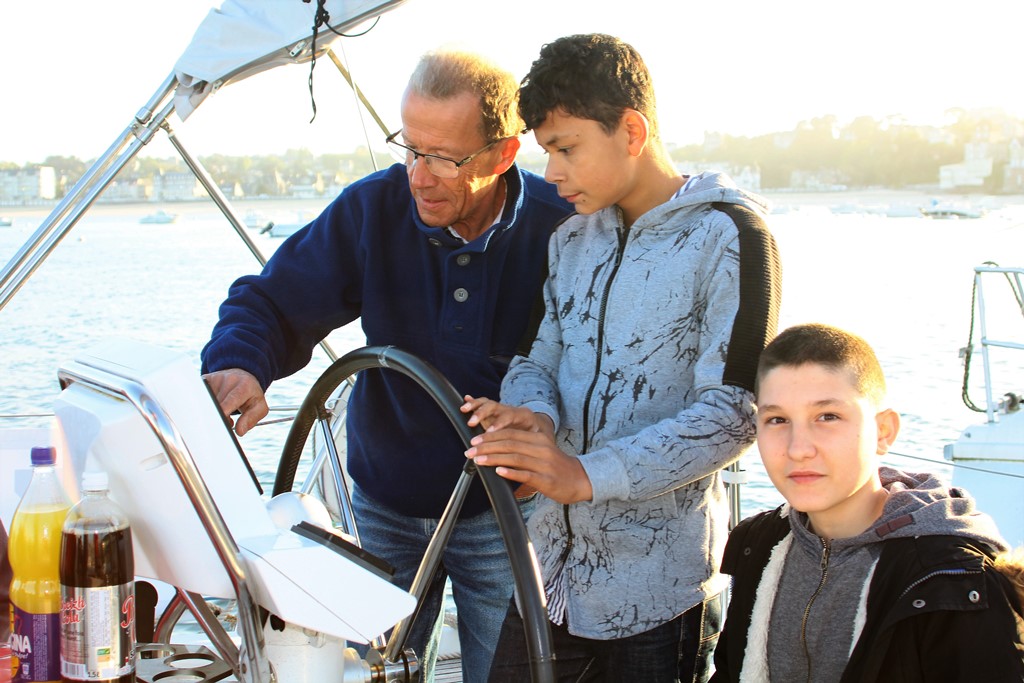 Un jeune à la barre accompagné par un adulte